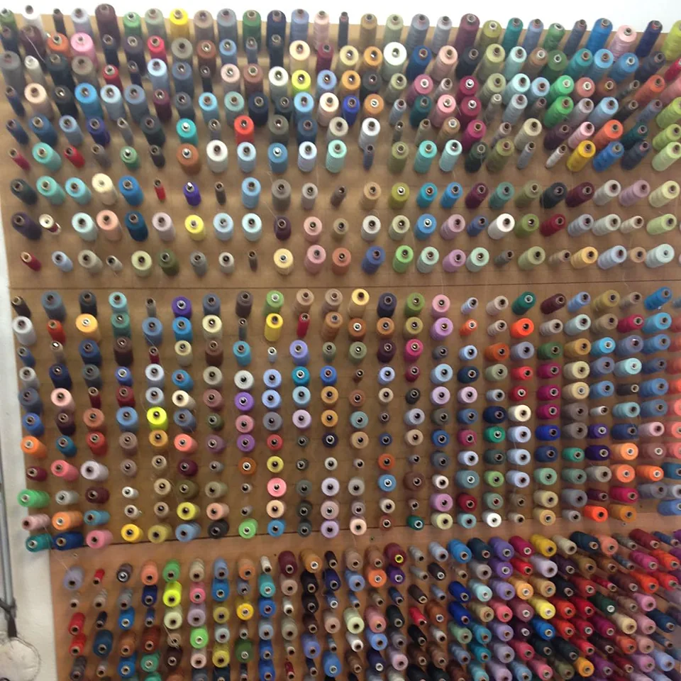 Een hele wand met klossen garen in honderden kleuren