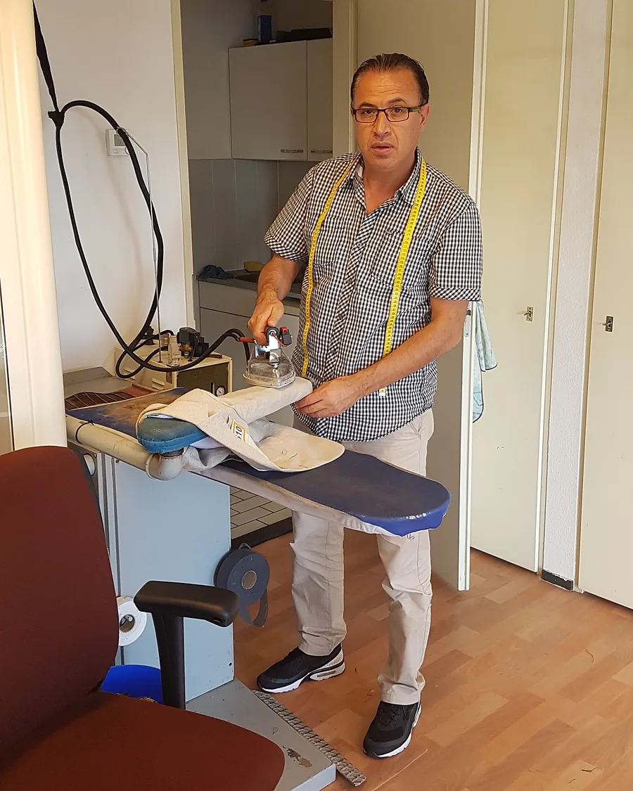 Rafo perst een kledingstuk op de strijktafel